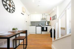 a kitchen with a table and a clock on the wall at Central Buckingham Apartment #1 with Free Parking, Pool Table, Fast Wifi and Smart TV with Netflix by Yoko Property in Buckingham