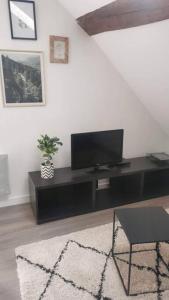 een woonkamer met een flatscreen-tv op een tafel bij Appartement cosy centre ville in Langres