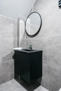 ein Bad mit einem schwarzen Waschbecken und einem Spiegel in der Unterkunft Stay Fløyen in Bergen