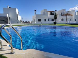 a large blue swimming pool in front of a building at PANORAMIC design home in Finestrat