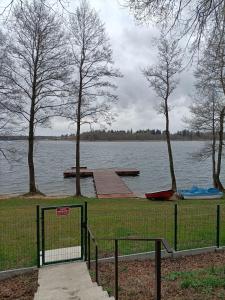 a park with a dock and a fence next to a lake at Zielona Ostoja in Ryn