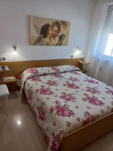 1 dormitorio con 1 cama con edredón de flores en Casa Stefy Gubbio Centro, en Gubbio