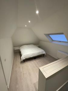 a small bedroom with a bed in the attic at Vakantieverblijf De Munt in Oudenburg