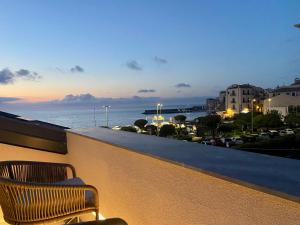 un par de sillas sentadas en un balcón con vistas al océano en Salemare Rooms & Suites, en Cefalú