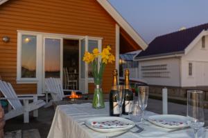 a table with two glasses and a vase with yellow flowers at RoaldsPiren Stavanger in Stavanger +43 photos