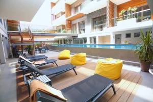 Luxury Apartment at Corniche , Seaview Close Beach في الدار البيضاء: فناء مع كراسي ومسبح في مبنى