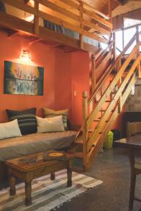 a living room with a couch and a staircase at El Colibrí Cabañas de la Naturaleza in Trelew