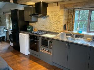 a kitchen with a sink and a stove top oven at The Sawmill in Beaminster