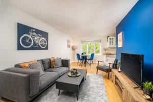 uma sala de estar com um sofá e uma televisão em Homely and Stylish Bermondsey Apartment with Parking em Londres