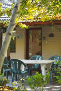 una mesa y sillas frente a una casa en El Colibrí Cabañas de la Naturaleza en Trelew