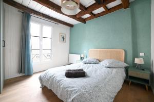 - une chambre avec un grand lit aux murs bleus dans l'établissement Maison avec spa dans l'hyper centre de Poitiers, à Poitiers