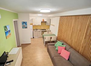 un soggiorno con divano e cuscini colorati. di Le Dune Ground Floor Apartments - Futura CAV a San Vincenzo