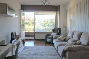 a living room with a couch and a large window at AMANE Lekeitio, Parking Incluido in Lekeitio