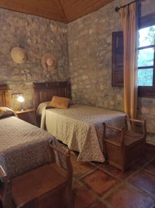 sypialnia z 2 łóżkami i oknem w obiekcie Posada del Moral w mieście Benaoján