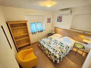 una piccola camera con letto e sedia di Le Dune Ground Floor Apartments - Futura CAV a San Vincenzo