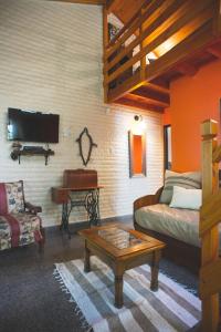 a living room with a bed and a couch and a table at El Colibrí Cabañas de la Naturaleza in Trelew