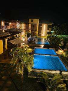 una piscina por la noche con un complejo en Kioara Itacimirim - espaço de acolhimento e sossego, en Itacimirim