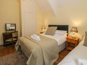 1 Schlafzimmer mit 2 Betten und einem Spiegel in der Unterkunft The Mill House in Carrog