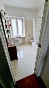 Baño blanco con lavabo y aseo en Fontecorona Bed and Breakfast en Serra San Quirico
