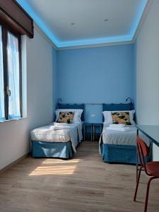 Habitación azul con 2 camas y silla en Toledo apARTment, en Nápoles