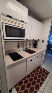 a kitchen with white cabinets and a microwave at NAÜTIK, Ocean Front! Great view in Fajardo