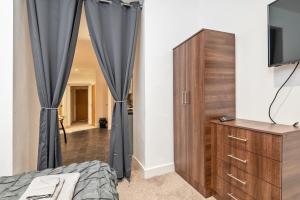 Luxe Apartment Central Bradford في برادفورد: غرفة نوم مع سرير وخزانة