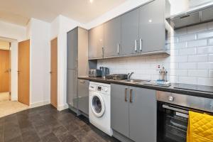 een keuken met een wasmachine en een wasmachine bij Luxe Apartment Central Bradford in Bradford