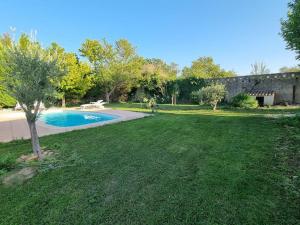 Blick auf einen Garten mit Pool in der Unterkunft villa avec studio indépendant et piscine in Jonquières
