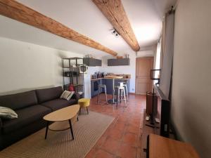 ein Wohnzimmer mit einem Sofa und einem Tisch in der Unterkunft villa avec studio indépendant et piscine in Jonquières