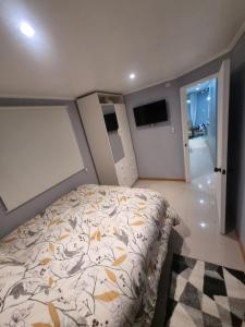 ein Schlafzimmer mit einem Bett mit einer Bettdecke darauf in der Unterkunft Cabaña in Ancud
