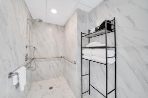 baño con paredes de mármol blanco y estante con toallas en Montreal Beach Resort, en Cape May