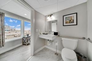 a bathroom with a toilet and a sink and a window at Montreal Beach Resort in Cape May