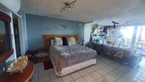 Un dormitorio con una cama y un sofá. en NAÜTIK, Ocean Front! Great view, en Fajardo