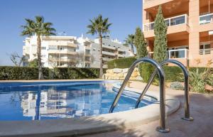 a swimming pool in front of a building with palm trees at Saltwater Apartment in Portimão