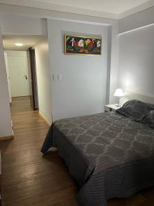 1 dormitorio con 1 cama y una pintura en la pared en SUITE 76 en Apart Lima 265 en Buenos Aires