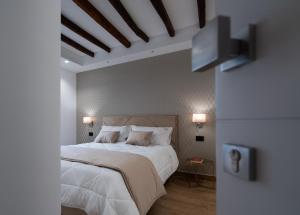 a bedroom with a large white bed and a tv at Sofi' Center Rooms in Sciacca