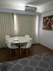 a dining room with a white table and chairs at SUITE 76 en Apart Lima 265 in Buenos Aires