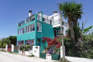 a blue and white house with a palm tree at Natural Mystic Hostel in Costa da Caparica