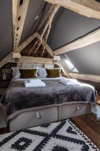 a bedroom with a large bed in an attic at Cheshire Boutique Bathhouse in Nantwich