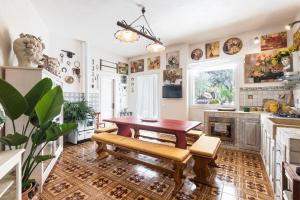 a kitchen with a wooden table and benches in a room at Dream House in Noto