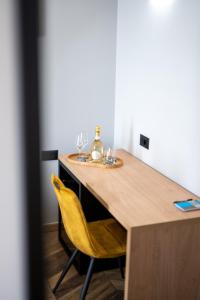 a table with a yellow chair and wine glasses on it at West Coast Deluxe Rooms in Split