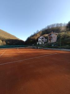 einen Tennisplatz mit Häusern im Hintergrund in der Unterkunft Kursumlijska banja apartman 4+1 in Kursumlijska Banja