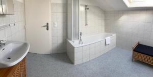 une salle de bain blanche avec une baignoire et un lavabo dans l'établissement Apartment Lisa - by Alpen Apartments, à Zell am See 6 autres photos