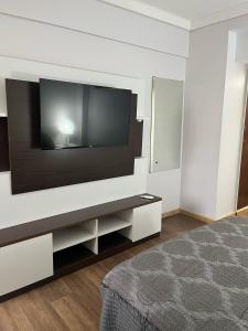 a bedroom with a large flat screen tv on a wall at SUITE 76 en Apart Lima 265 in Buenos Aires