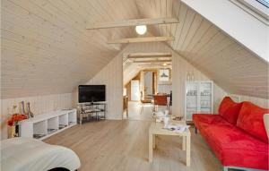 a living room with a red couch and a tv at Gorgeous Apartment In Pandrup With Kitchen in Pandrup