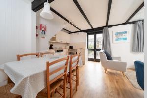 cocina y comedor con mesa y sillas en Heron Cottage at Robin Hill 6 en Bideford