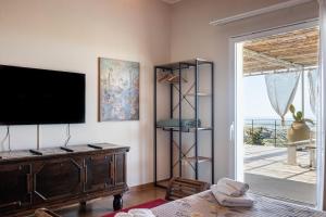 a living room with a flat screen tv on a wall at Dream House in Noto