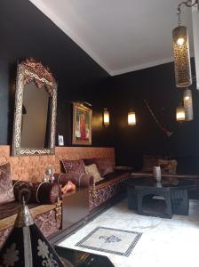 a living room with a couch and a mirror at Riad Dar Badiaa in Sale