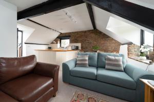 een woonkamer met een blauwe bank en een stoel bij Swallow Cottage at Robin Hill 4 in Bideford