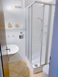 ein Bad mit einer Dusche und einem Waschbecken in der Unterkunft Deickrone App 10 inkl WLAN in Grömitz